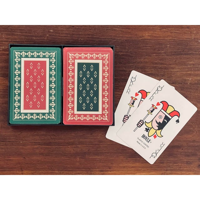 A pair of coordinated playing card decks, printed with an 18th century rug inspired design each in an inverted color...