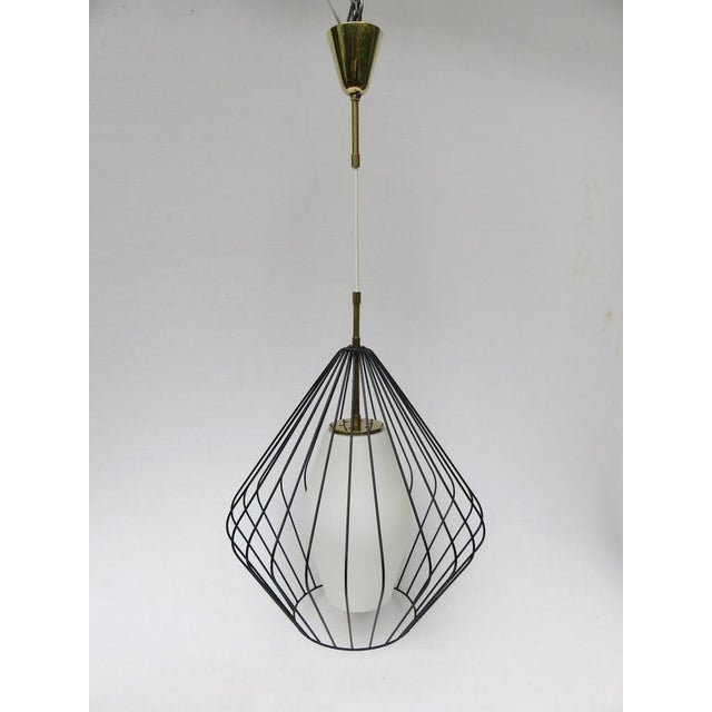 An extraordinary ceiling light from the 1950s. A white, satin double cone made of overfucking glass is surrounded by a...