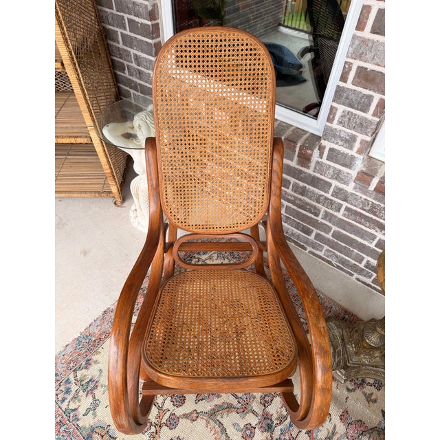 Beautiful pair of vintage bentwood cane rocking chairs. Features classic curved wood frames with woven cane backs and...