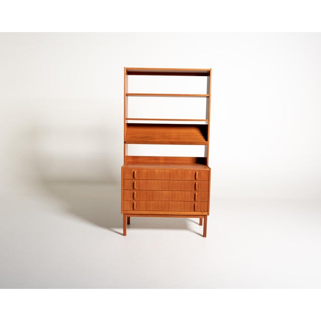 Teak structure with four large drawers, a slanted top, and an open upper section with adjustable shelves. Designed by...