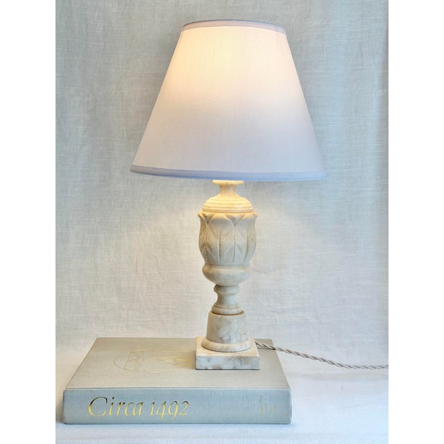 Vintage Italian table lamp carved from solid alabaster, with a classical urn-form silhouette, square base, and softly...