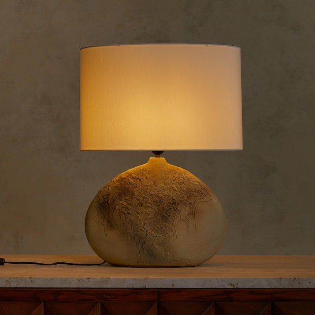 A French table lamp from the 1970s, signed by the artist and sculpted in ceramic with a rich matte glaze and textured...