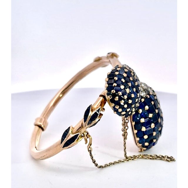 This is an opulent rose gold bypass watch featuring two large, dome-shaped clusters pavé-set with deep blue sapphires...