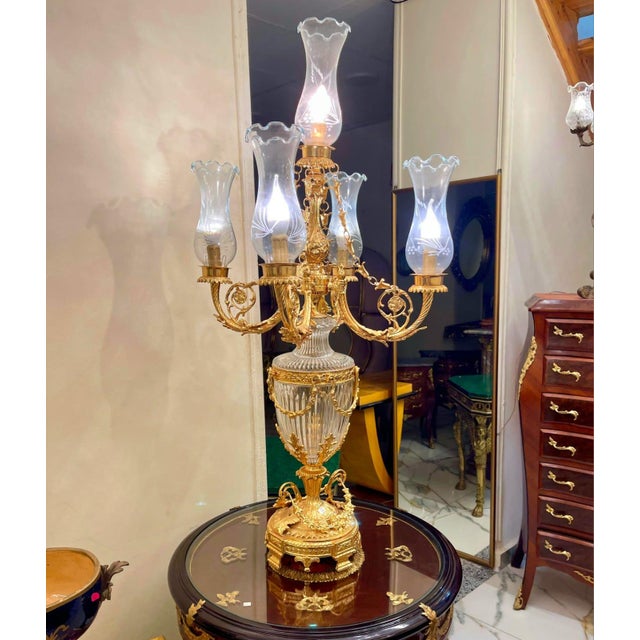 An exceptional French Empire-style table lamp featuring five elegantly scrolled arms, finely detailed gilt bronze mounts,...