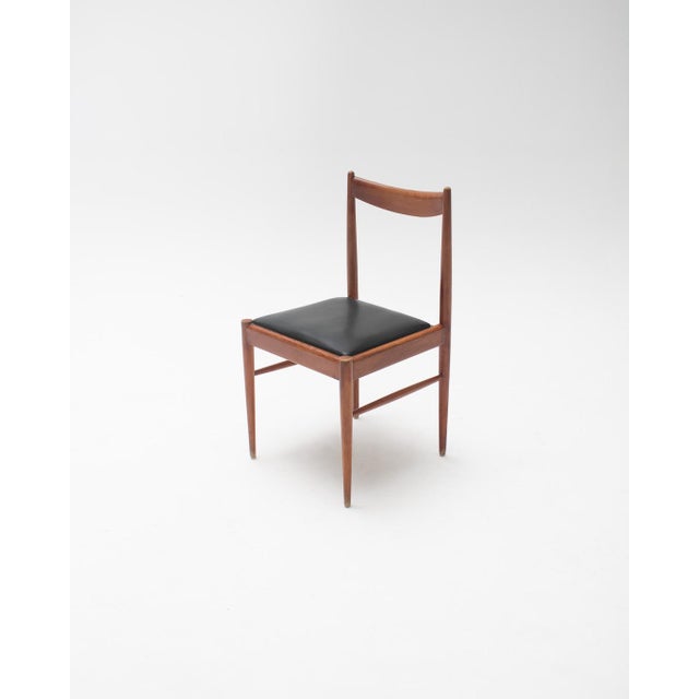 Set of 6 Scandinavian-style dining chairs with solid wood frames and black upholstered seats, inspired by Nordic design...