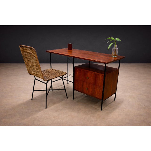 This pair of chairs reflects the Brazilian modernist interest in combining industrial structure with natural fiber. Each...