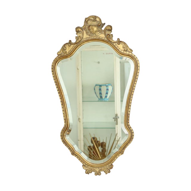 Mid-century Deknudt mirror in a classic wooden frame gilded with gold leaf; the mirror glass is beveled, and the mirror is...
