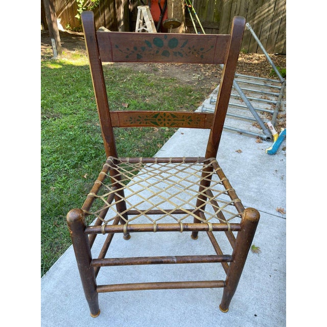 Matching set of 9 antique American slat-back chairs with original painted decoration and woven rawhide seats. Green...