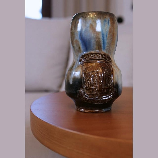 A glazed stoneware vase by roger guérin, dating from the first half of the 20th century. Shades of cobalt blue, brown, and...