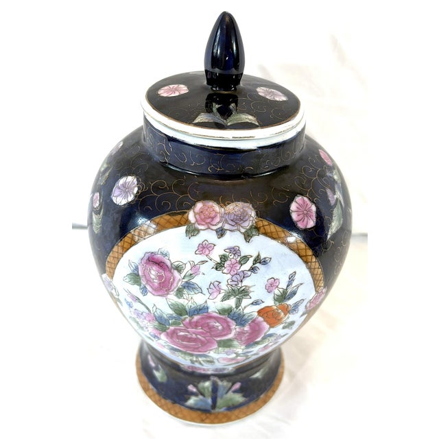 Pretty Chinese Famille ginger jar from the late 20th century. The unique piece is made of porcelain with a navy background...