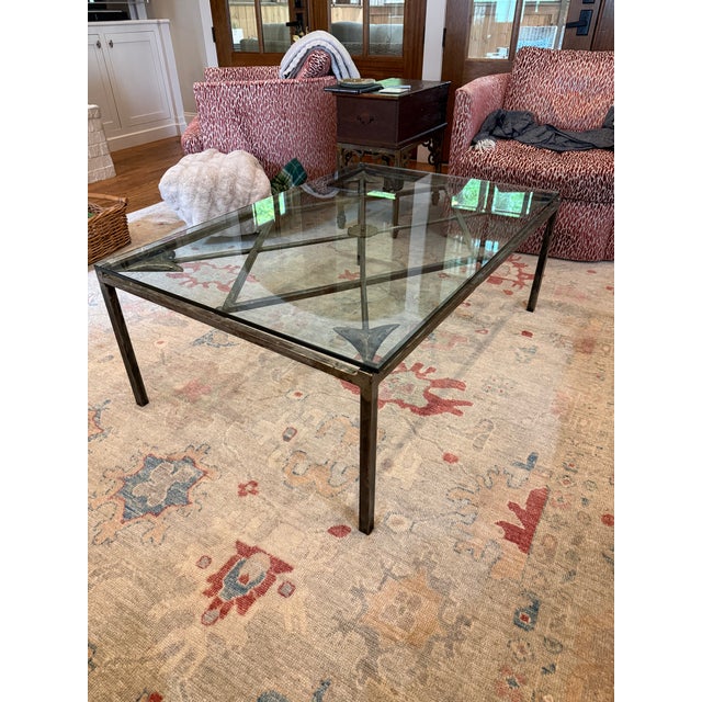 Large hammered iron coffee table with criss cross detailing including an arrow motif and a central medallion. 47.25”L x...