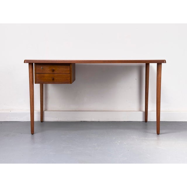 Compact desk with a solid teak top, beneath which is a cabinet with two drawers, the upper one lockable. A clean, timeless...