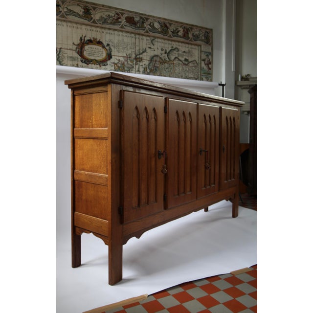 Large carved oak cabinet from Belgium, dating from circa 1960. The cabinet takes its inspiration from Gothic furniture and...