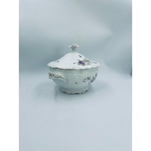This antique Art Nouveau soup tureen is crafted from high-quality white porcelain. The tureen features a fitted lid with a...