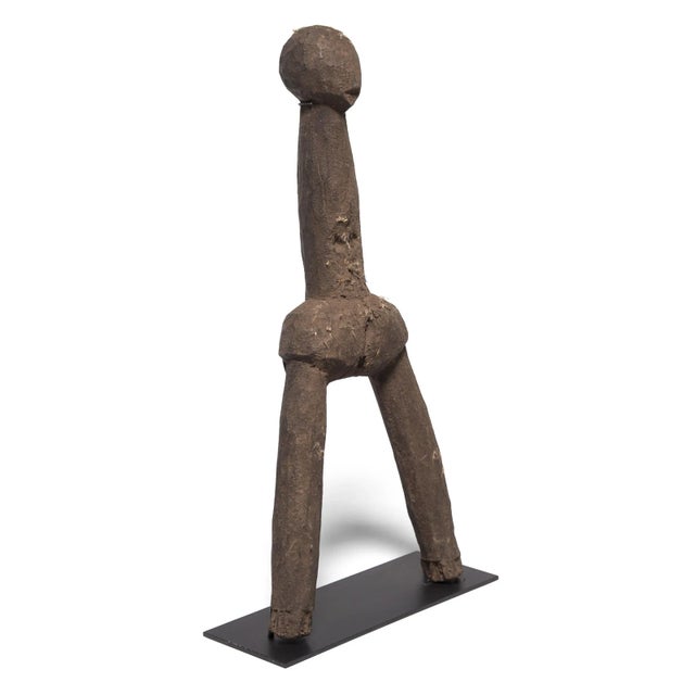 For the Dagari people of Burkina Faso and Ghana, this abstract figure embodied the lingering spirit of an ancestor. Tucked...