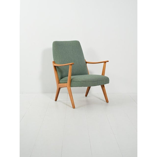 High-back beech armchair from the 1950s–60s. Original sage green wool upholstery, oblique lines, and a soft profile. A...