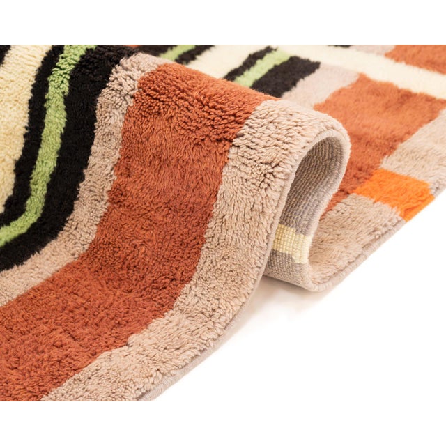 Sophisticated Hand-knotted wool rug featuring a mosaic of Sunlit Sienna, Forest Green, Lime Green, Taupe, and Midnight...