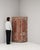A cabinet whose distressed red/rust painted carved wood gives it real character at first glance. It was made in Sweden...
