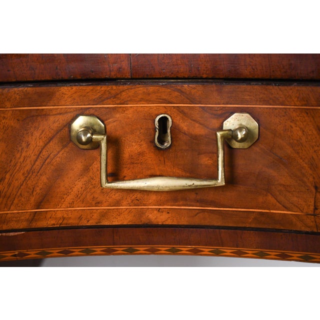 A finely proportioned English Regency period Hepplewhite mahogany serpentine sideboard, with a paneled and elevated...