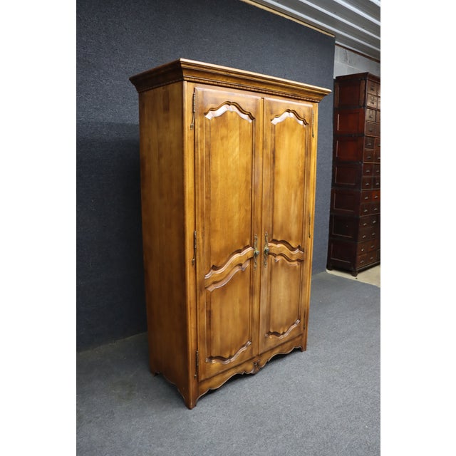 Ethan Allen cherry linen press featuring French Provincial styling, carved serpentine panel doors, decorative crown...