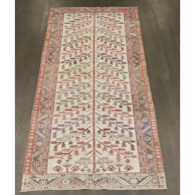 An early 20th century Bakhtiari Rug sporting a tree branch pattern on an ivory field