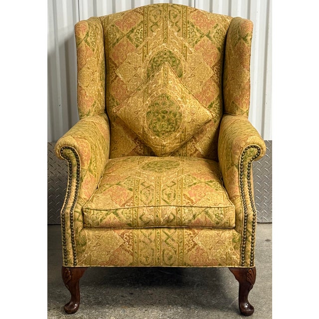 A classic silhouette with a wingback design and rolled, flared arms. Features ornate tapestry pattern in tones of gold,...