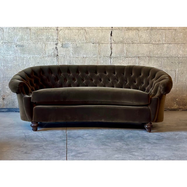 An Antique Curved Chesterfield. Recently recovered in exquisite dark green velvet and featuring a tufted seat back and...