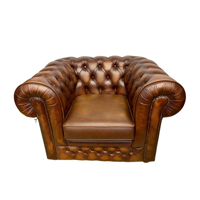 British classic Chesterfield leather club chair with deep button tufting and rolled arms. Solid frame with bun feet and...