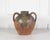 Made in France around 1780, this unglazed earthenware oil pot is decorated with a green splash glaze and impressed...
