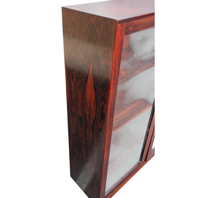 This Rosewood display cabinet, attributed by design to Danish modern production of the 1960s presents beautifully with an...