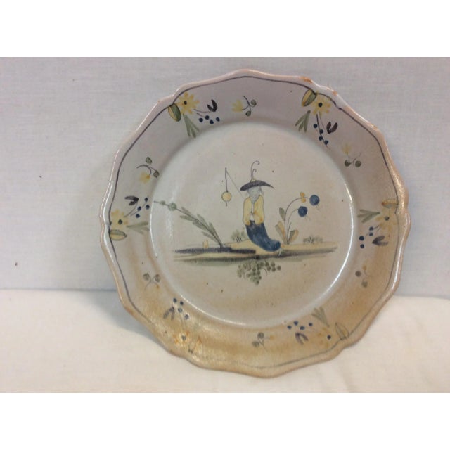 Decorative bowl or shallow plate. This charming piece has a fishing figure painted on it. Has flawed glazed surface.