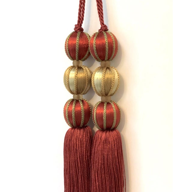 Festive pair red satin beaded key tassels in a terracotta - red with gold details. Wrapped satin beads are surrounded by...