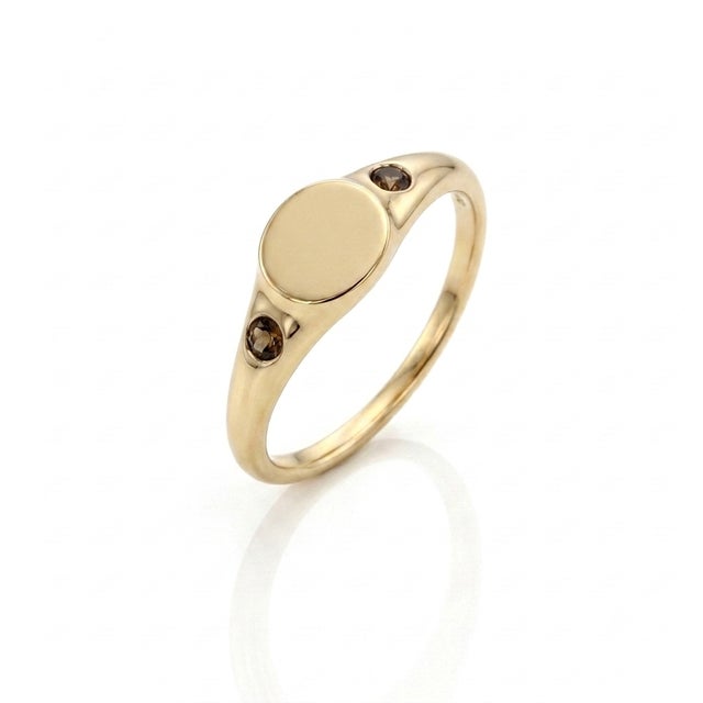 Add a whisper of edgy elegance to your jewelry box. This sleek, blank oval signet ring is flanked by two rich, flush-set...