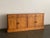 Bold, knotty pine planks define the facade of this commanding modernist sideboard, their swirling organic grain providing...