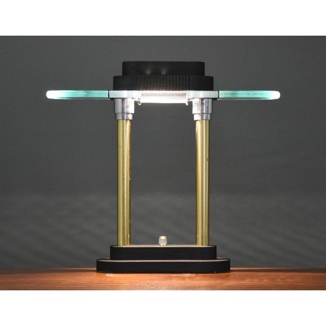 A mid century modern brass and glass desk task table lamp with a black base by Robert Sonneman for George Kovacs. Light...