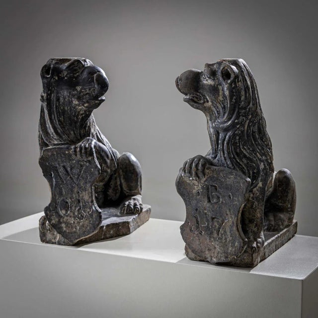 A pair of lions of the same design made of stone with escutcheons. Together they bear the date 1701 and the monogram B. W.