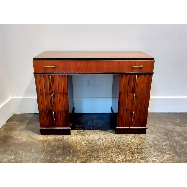Lovely little Art Deco desk, mahogany wood with brass and Bakelite pulls and black decorative trim. In good condition with...