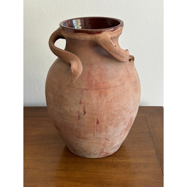 Hand-thrown antique terracotta storage jar featuring a classic rounded form with three sculptural pulled handles, an...