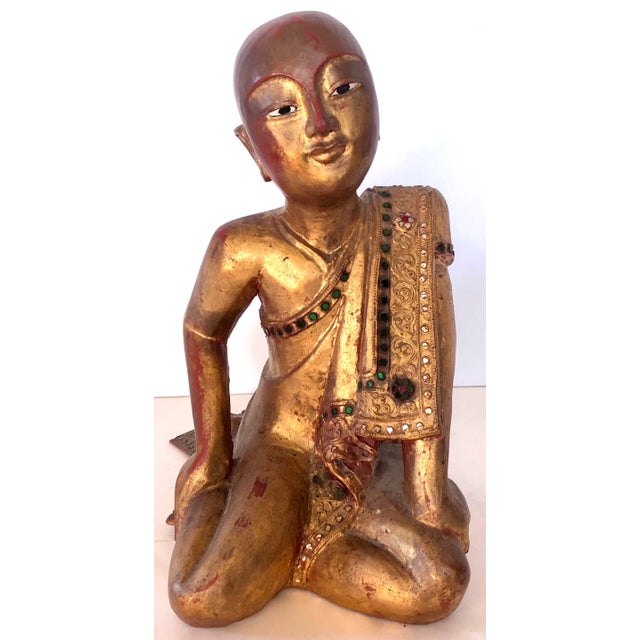 Two Mandalay monks are carved in wood and gilded. One monk is sitting in a praying position, the other with a relaxed...