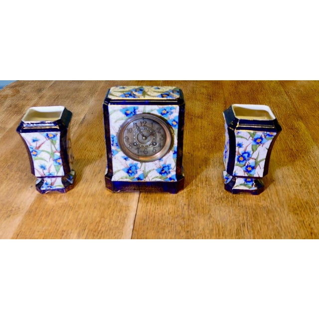 19th Century French Porcelain Clock Set The clock is housed in a beautiful Porcelain case decorated with blue flowers and...