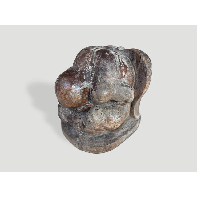 A praying Buddha hand carved from a single piece of wood. Circa 1930 This antique praying Buddha was sourced in the spirit...