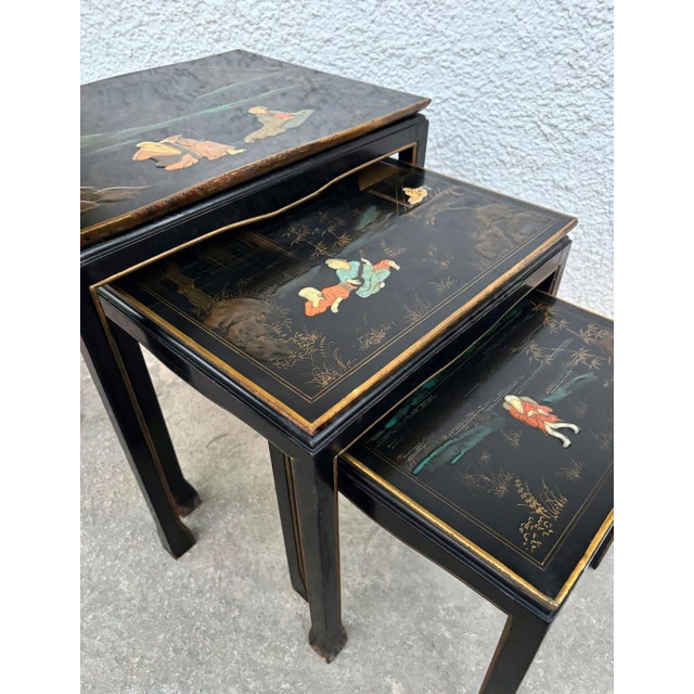 Set of three antique Chinese nesting tables, crafted in wood and finished in traditional black lacquer. Each tabletop is...