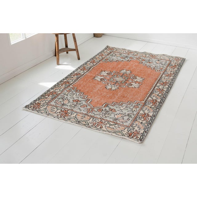 This is a vintage Turkish Oushak rug from the Mid 20th Century. The piece was hand-knotted.