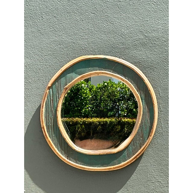 This vintage round wall mirror is a charming example of 1970s coastal design, combining the organic warmth of bent rattan...