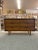 Walnut Toned 6 Drawer Low Dresser. Tapered Legs and Carved Wood Handles , Consistent with the Era it Was Made. Dovetail...