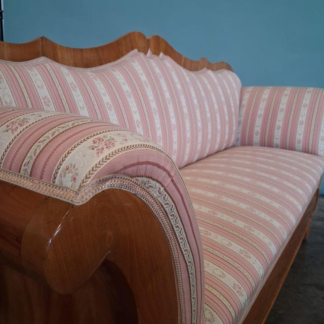 This Biedermeier sofa from the 19th century stands out for its balanced proportions, gently curved backrest and the warm...