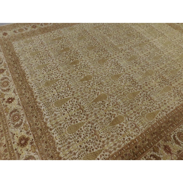 This extra fine hand-knotted rug, from Nasser Luxury Rugs, features intricate paisley floral pattern in cream, gold, tan...