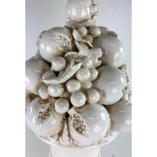 This is a large terra-cotta Italian topiary. The topiary features a cream colored antiqued glazed to the surface. The...