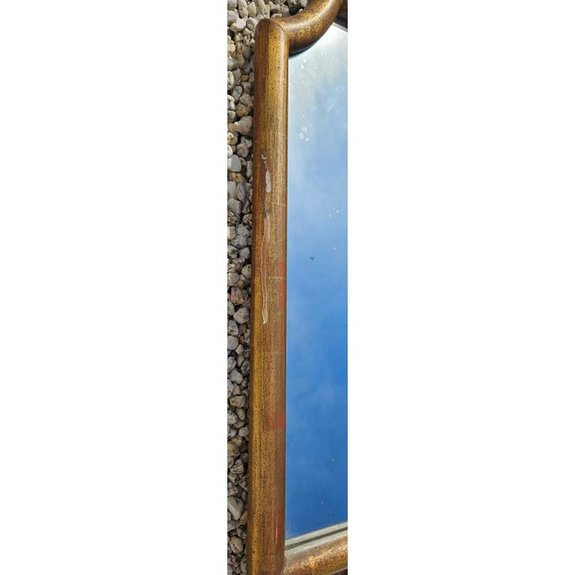 Antique mirror, original in its "gendarme hat" shape, made of gilded wood The gilding is partially worn in places The...