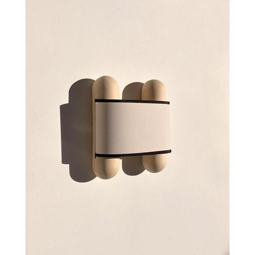Pergamino wall light by lisa allegra dimensions: w 34 x d 10 x h 30 cm materials: clay, almond finish with shade and black...